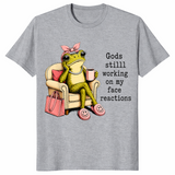 Sport Grey God's Still Working On My Face shirt with an unimpressed frog holding coffee