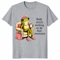 Sport Grey God's Still Working On My Face shirt with an unimpressed frog holding coffee