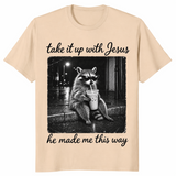 Take it up with Jesus shirt in sand, raccoon sipping iced coffee